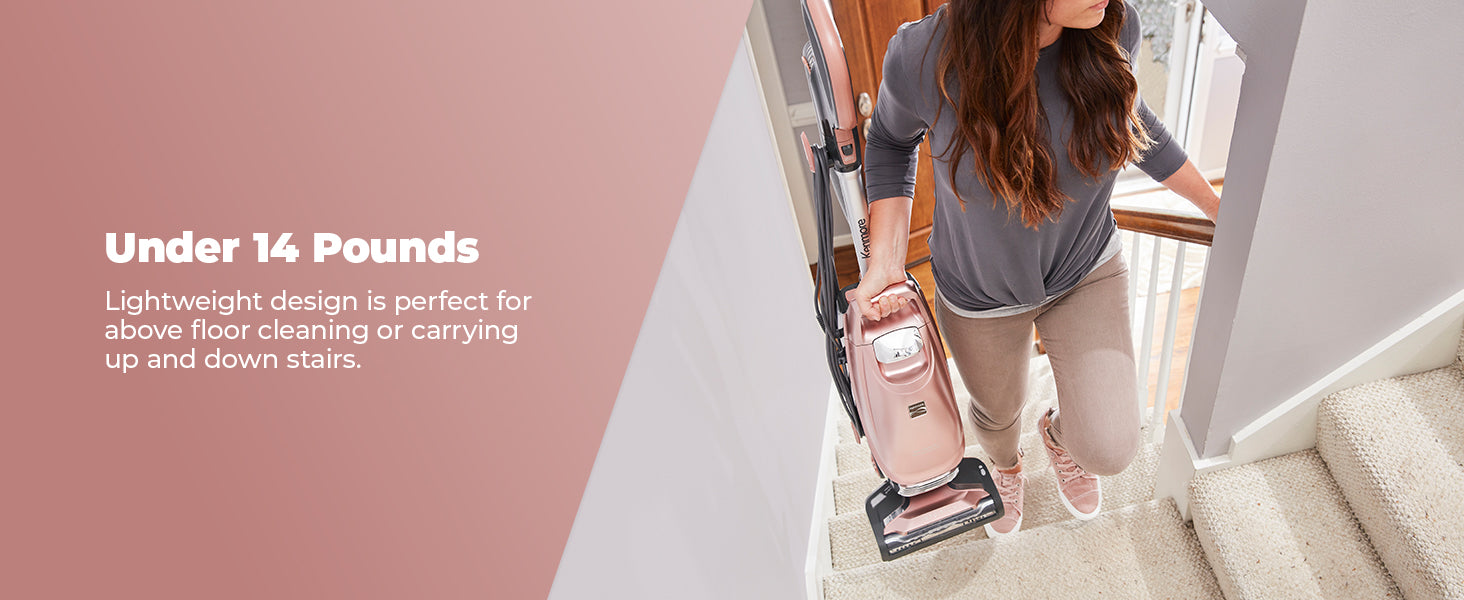 A woman carries a vacuum upstairs by the handle, with text that reads "under 14 pounds."