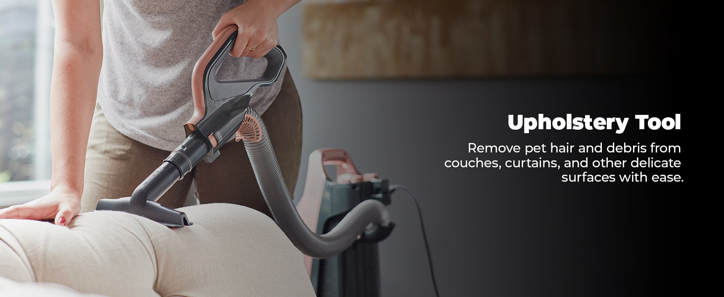 Person using a vacuum cleaner with an upholstery tool on a couch.