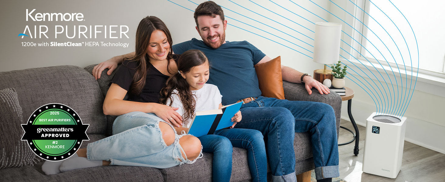 Family sitting on a couch with a Kenmore air purifier in the background