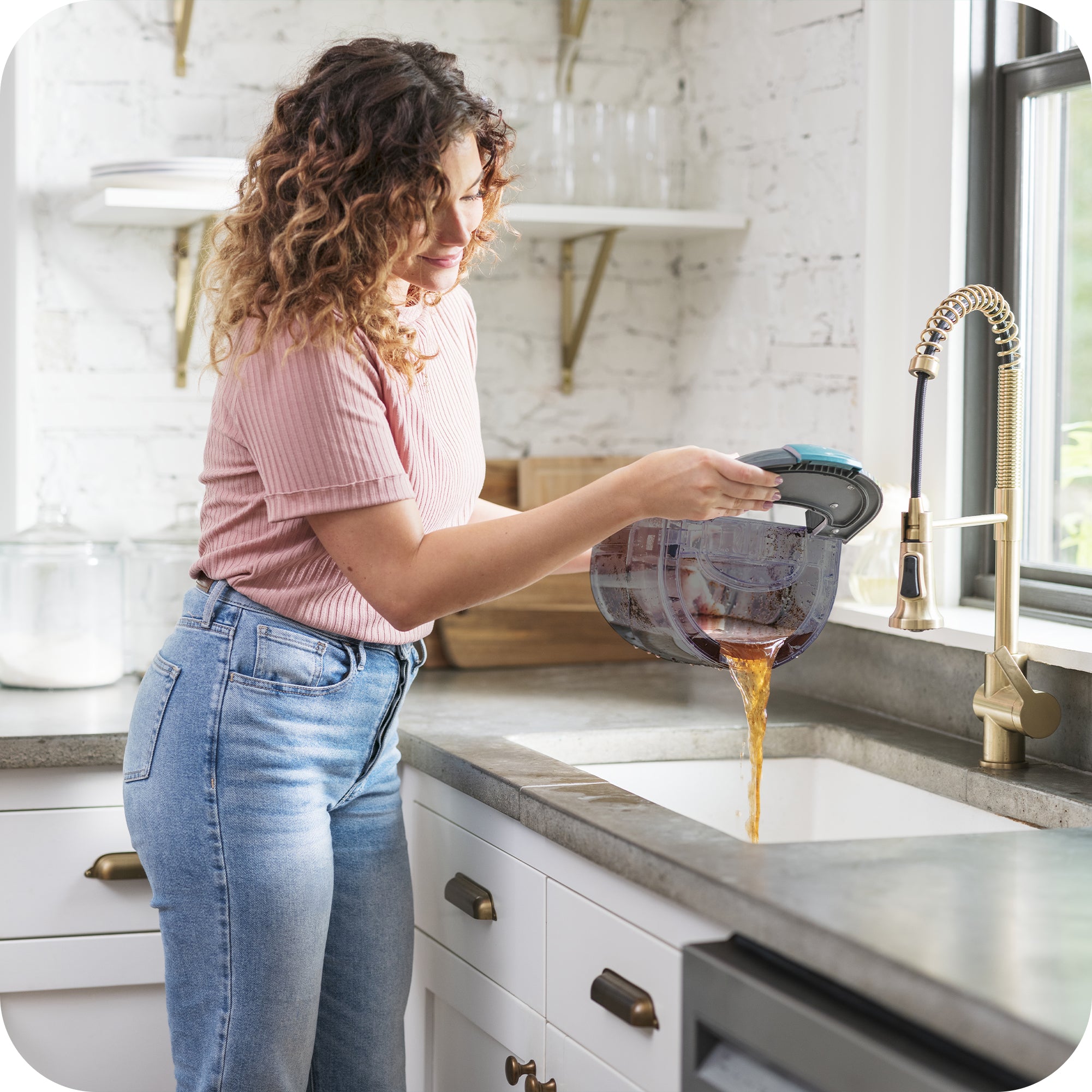 Woman easily empties dirty water tank into kitchen sink.