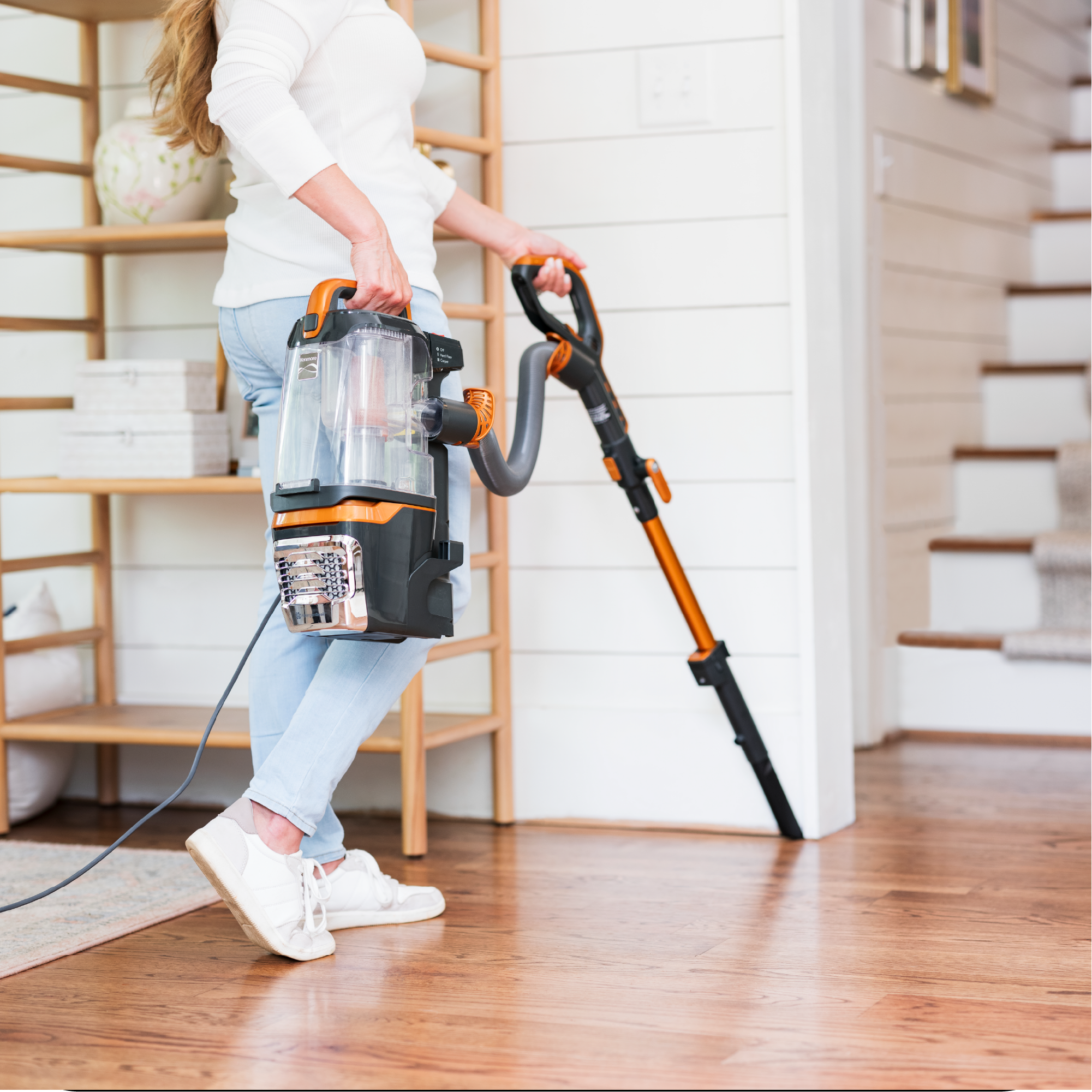 Person shown holding only the canister of vacuum to clean along baseboards, highlighting the LIft-Up feature.