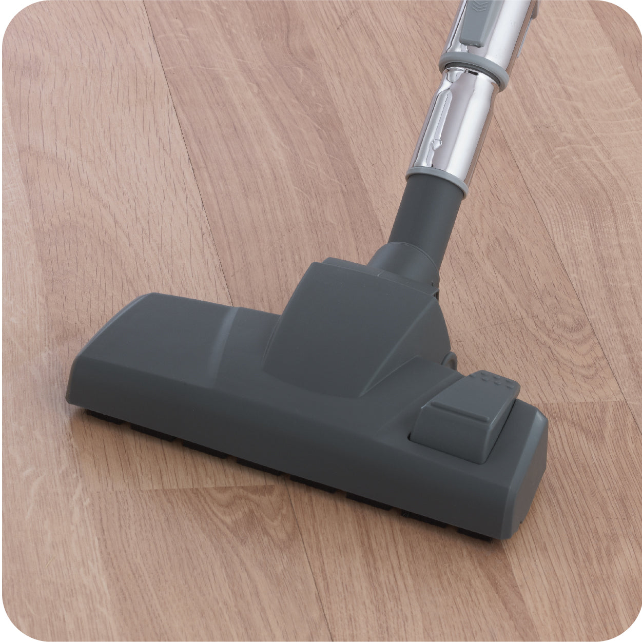 Gray canister vacuum cleaner on a wooden floor