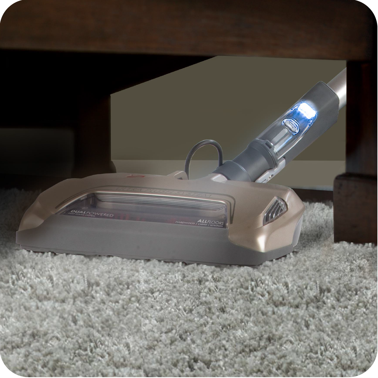 Close up of vacuum nozzle on a rug cleaning under chair or bench.