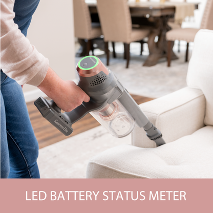 Person using a handheld vacuum cleaner on a white sofa with 'LED Battery Status Meter' text.