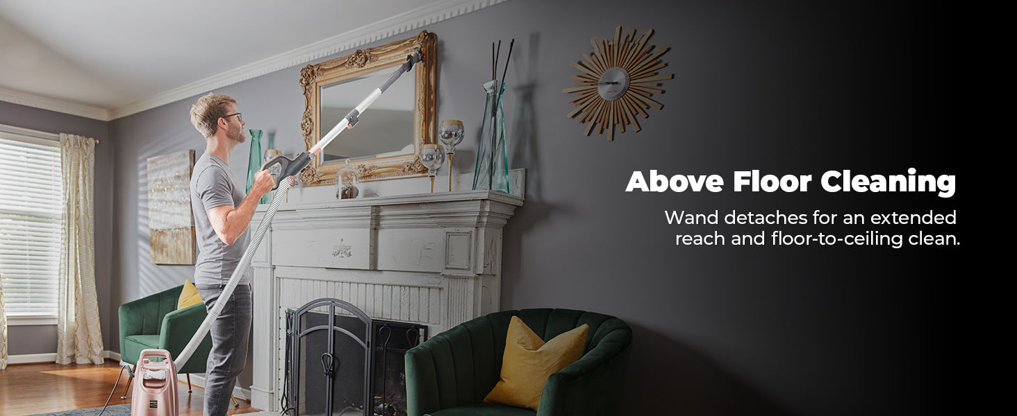 Person using a cleaning device in a living room with text 'Above Floor Cleaning' and 'Wand detaches for an extended reach and floor-to-ceiling clean'.