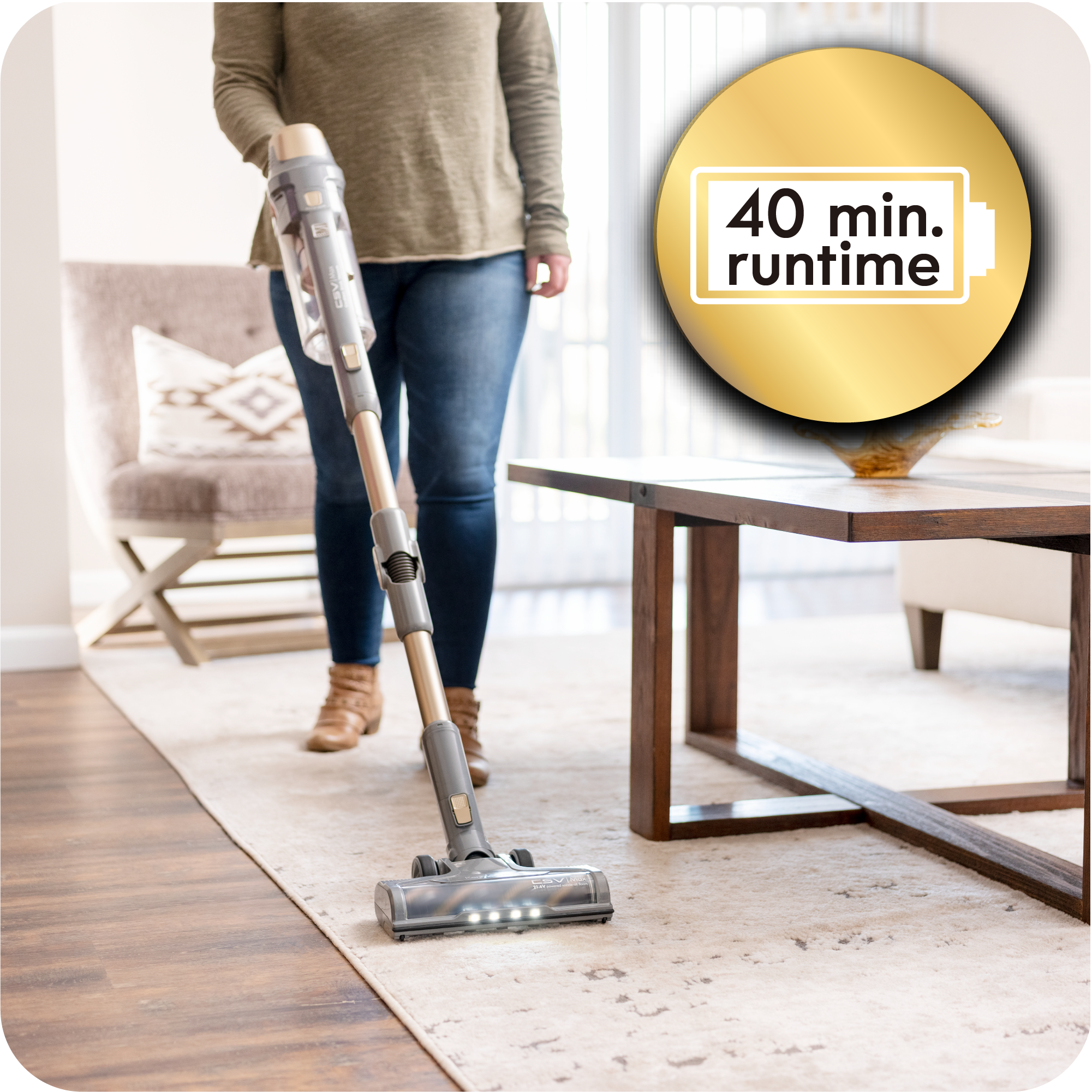 Person uses stick vacuum to clean rug with text that reads "40 min. runtime"