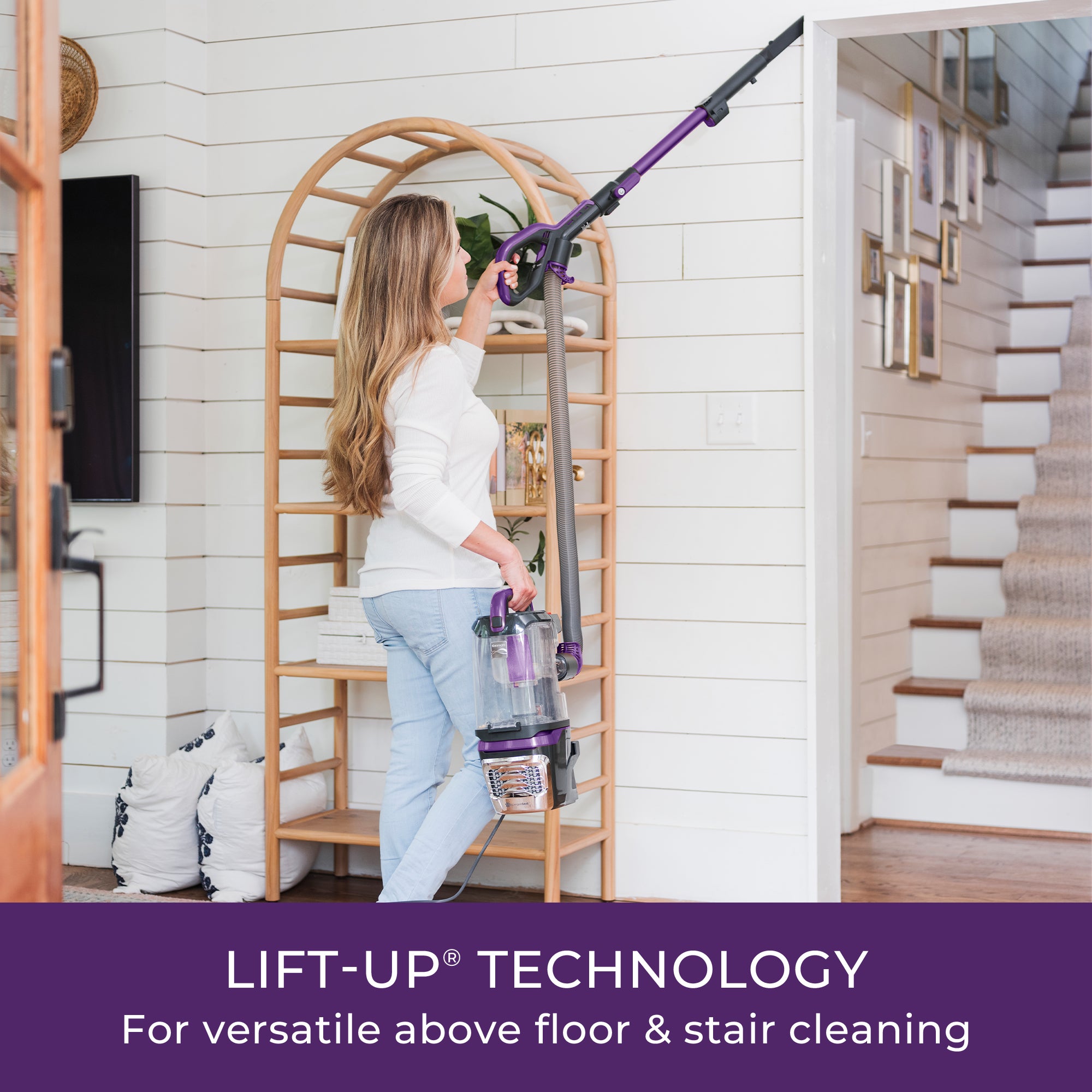 Woman using a vacuum cleaner with lift-up technology in a home setting.