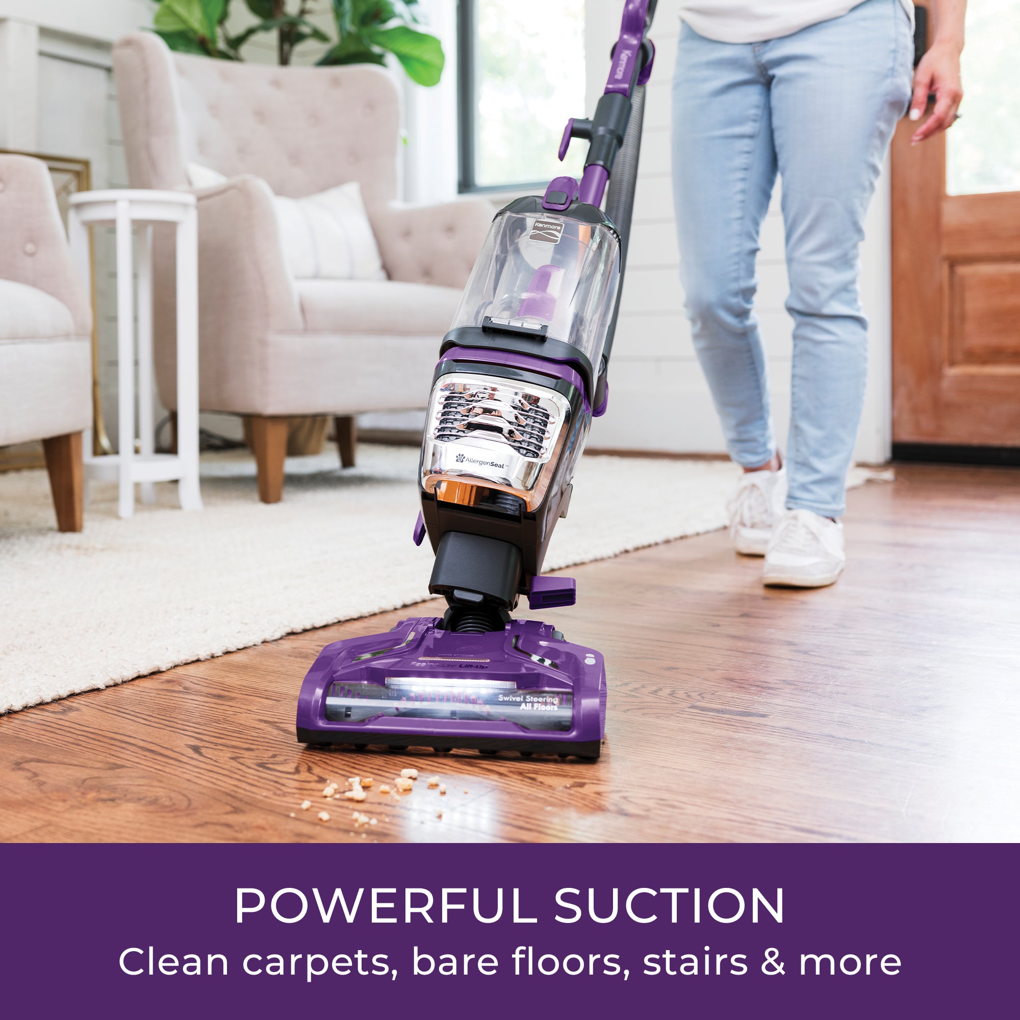Person using a purple vacuum cleaner on a wooden floor in a living room.