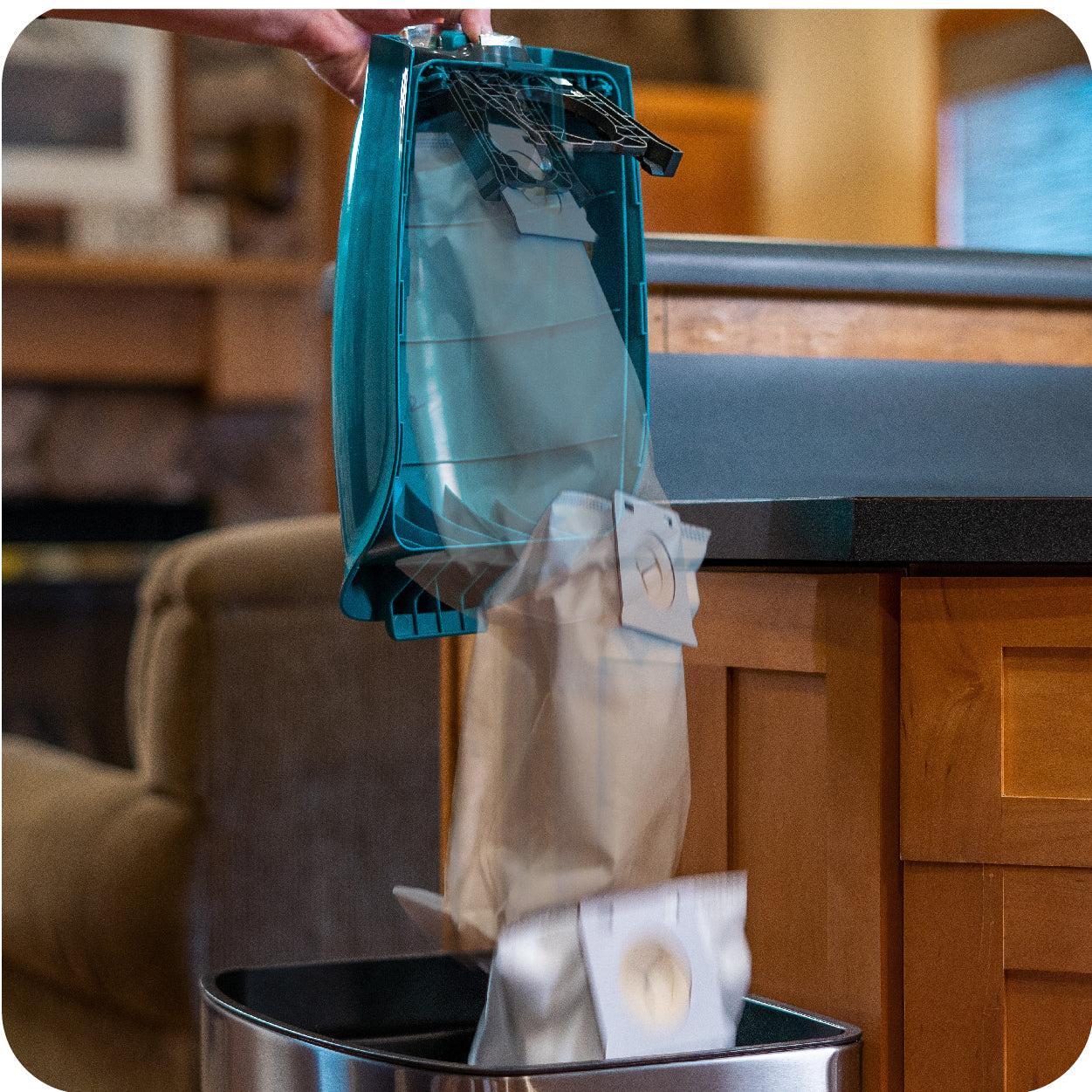 Person disposing of a full vacuum cleaner bag into a trash can with No-Touch Technology