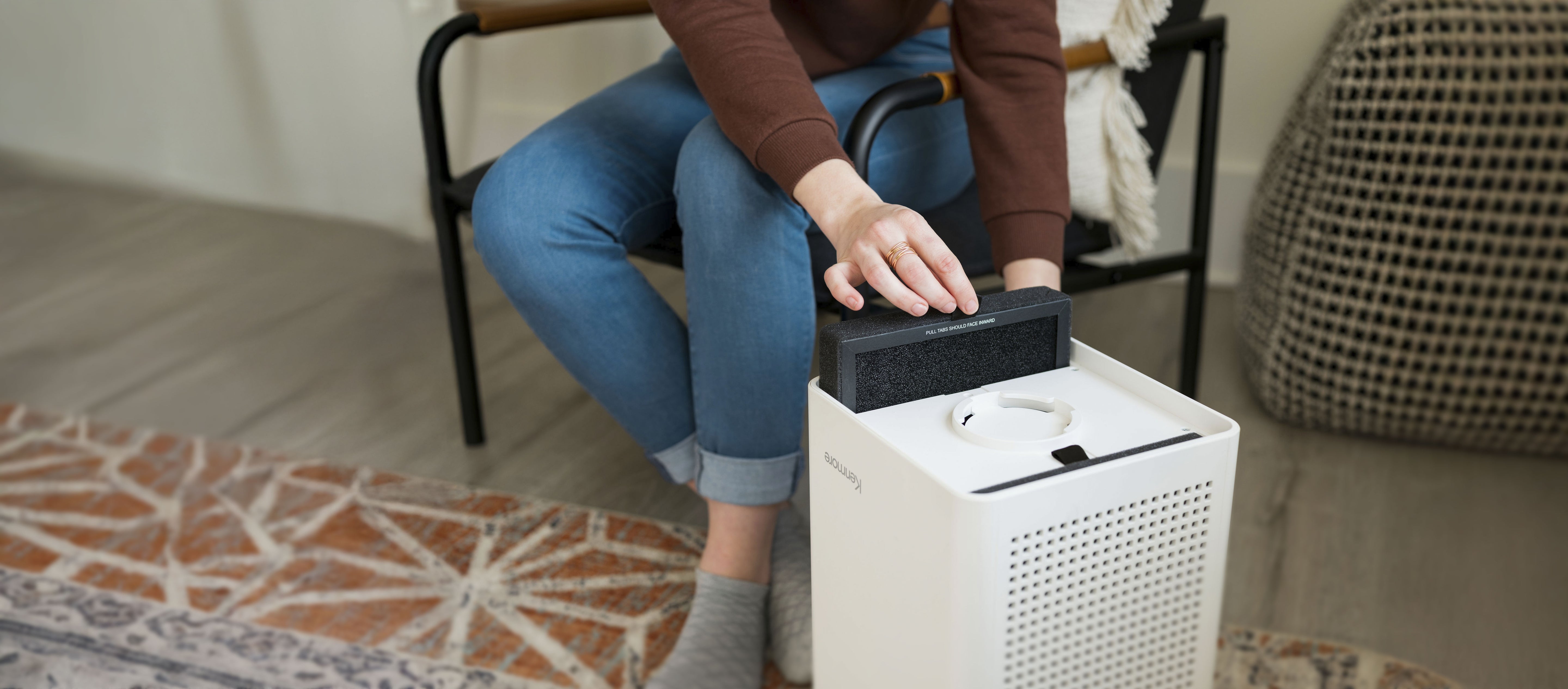 Person installing a filter into an air purifier 