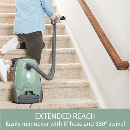 Person using a green vacuum cleaner on carpeted stairs with text 'EXTENDED REACH' and '8' hose and 360° swivel'.